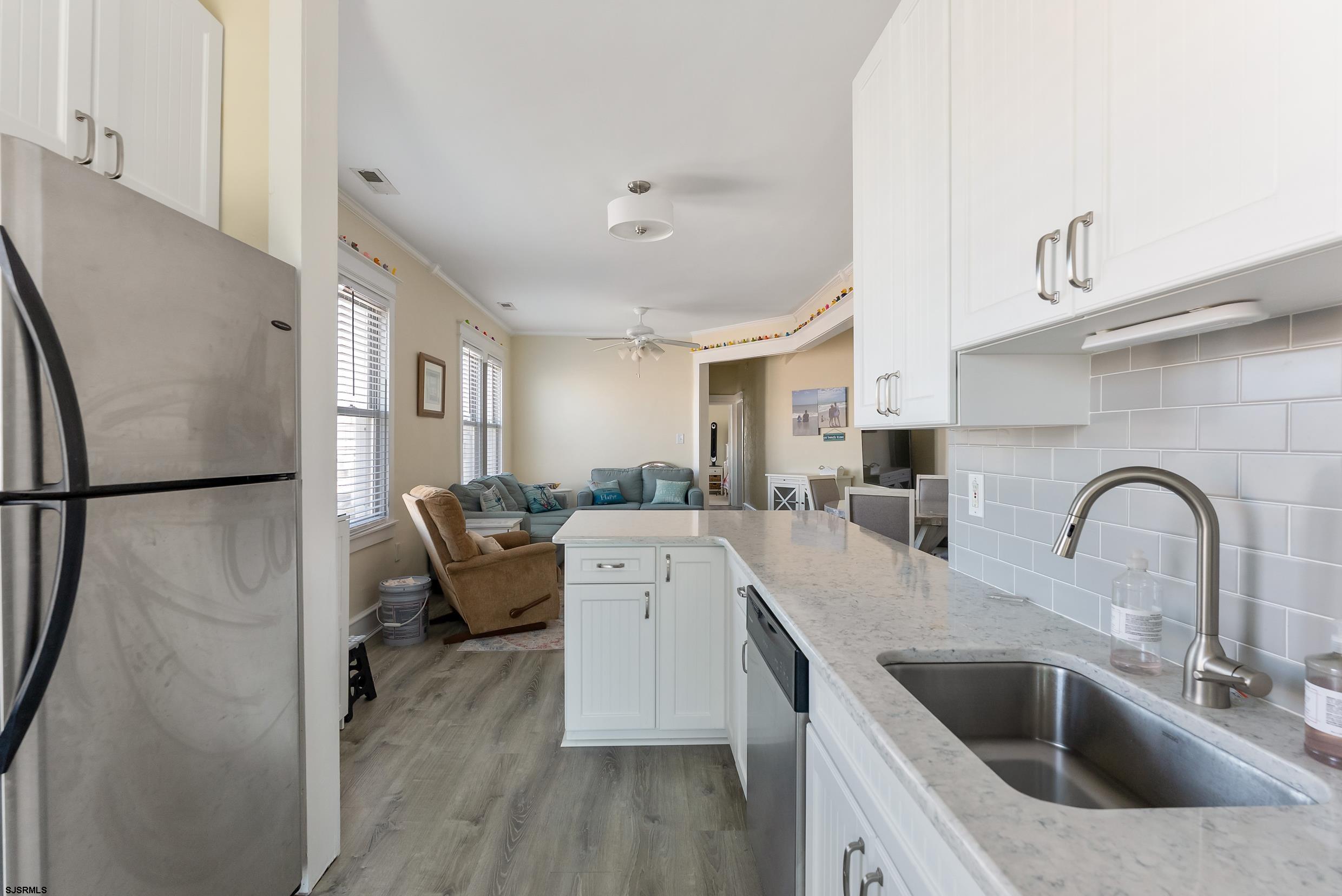 206 East Cardinal Road, Unit 4 Wildwood Crest, NJ 08260 - Photo 13 of 32 a kitchen with a refrigerator sink and white cabinets with wooden floor