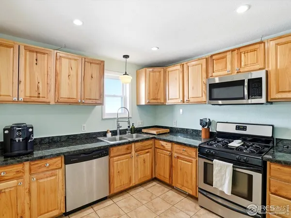a kitchen with stainless steel appliances granite countertop a sink stove and microwave
