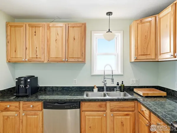 a kitchen with granite countertop a sink a stove and cabinets