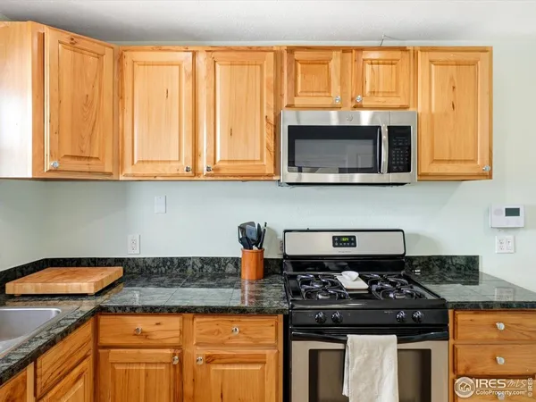 a kitchen with granite countertop a stove top oven microwave oven cabinets and a counter space