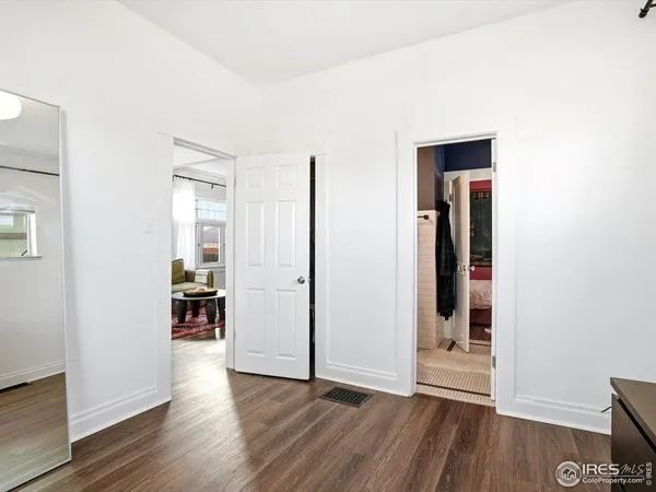 an empty room with wooden floor and closet