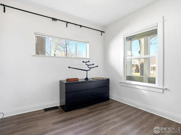 a room that has a dresser and wooden floor