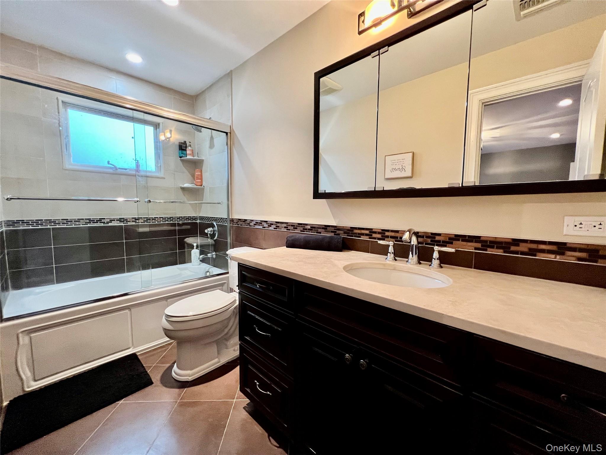 3683 Orchard Road Wantagh, NY 11793 - Photo 28 of 42 a bathroom with a sink a toilet a mirror and shower
