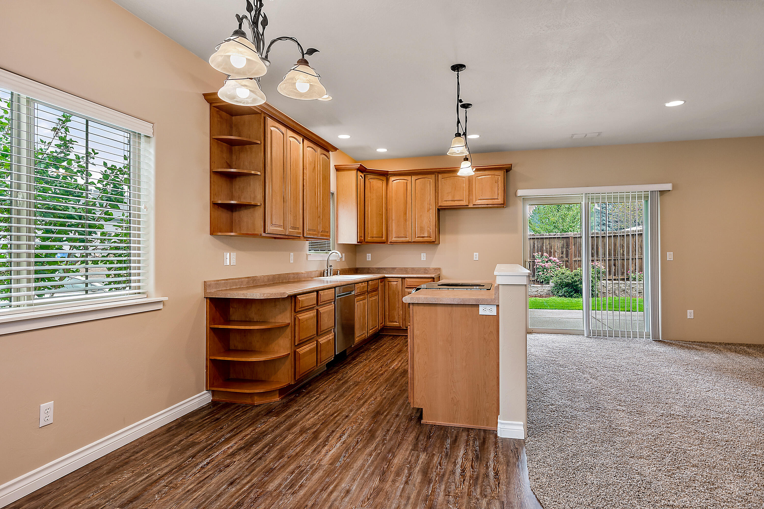 948 Win Way Eagle Point, OR 97524 - Photo 8 of 32 a kitchen with kitchen island granite countertop a stove a sink a refrigerator and a wooden floor