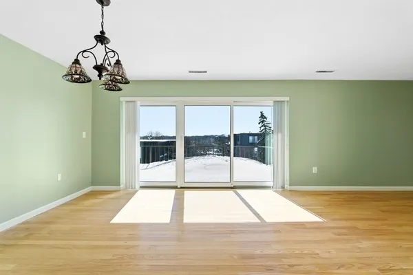 a view of a room with wooden floor and windows