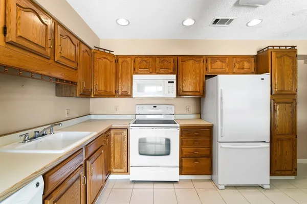 a kitchen with a refrigerator sink and cabinets
