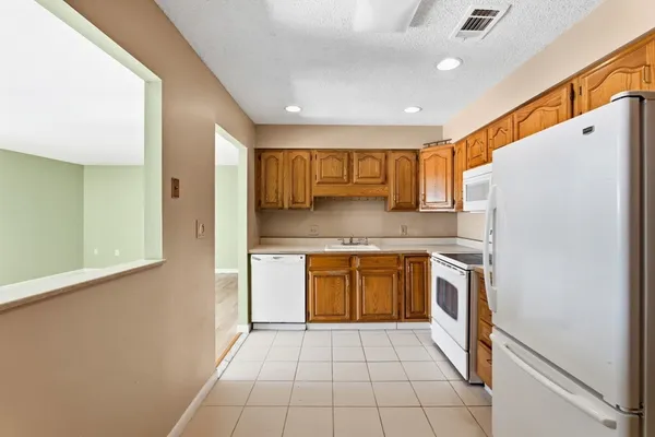 a kitchen with stainless steel appliances granite countertop a refrigerator and a stove top oven