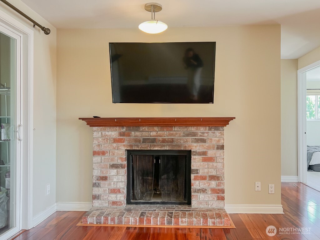 633 Northwest 85th Street, Unit 301 Seattle, WA 98117 - Photo 12 of 34 a living room with a fireplace and a flat screen tv