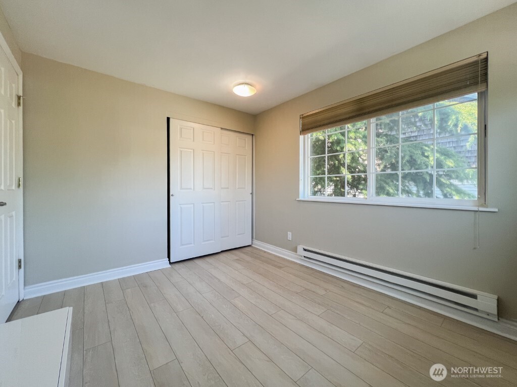 633 Northwest 85th Street, Unit 301 Seattle, WA 98117 - Photo 20 of 34 an empty room with wooden floor and windows