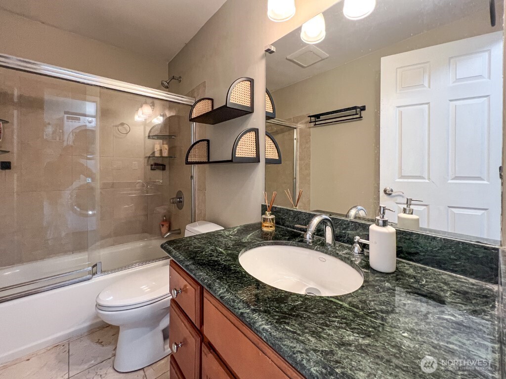 633 Northwest 85th Street, Unit 301 Seattle, WA 98117 - Photo 21 of 34 a bathroom with a granite countertop sink toilet and shower