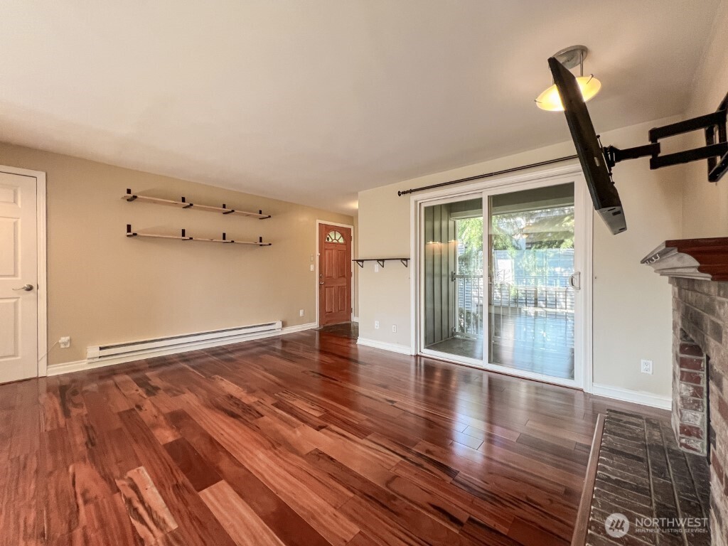 633 Northwest 85th Street, Unit 301 Seattle, WA 98117 - Photo 5 of 34 a view of an empty room with wooden floor and a window