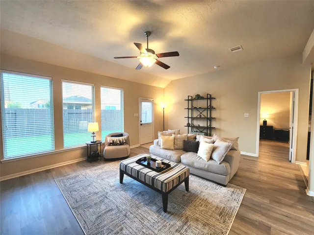 a living room with furniture and a large window with wooden floor