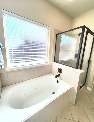 a white bath tub sitting in a bathroom next to a window
