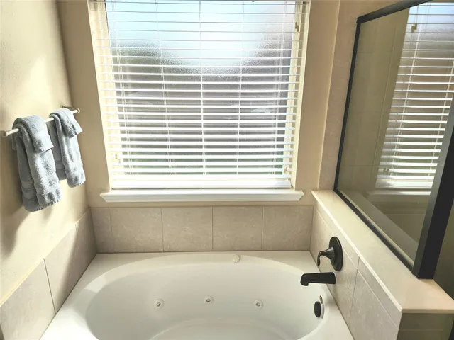 a bathroom with a tub and a window