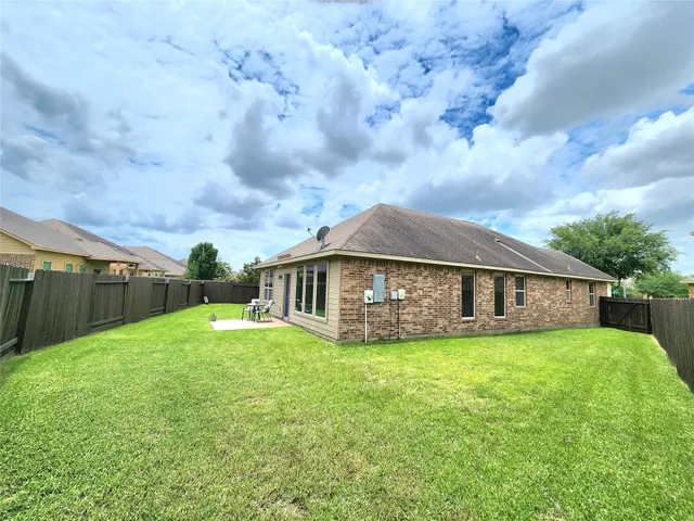 a view of a house with a yard and sitting area
