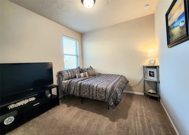 a bedroom with a bed and a flat screen tv