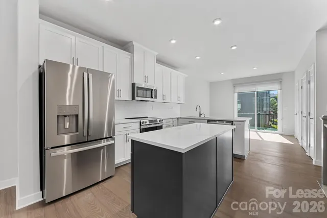 a kitchen with kitchen island a sink appliances and cabinets