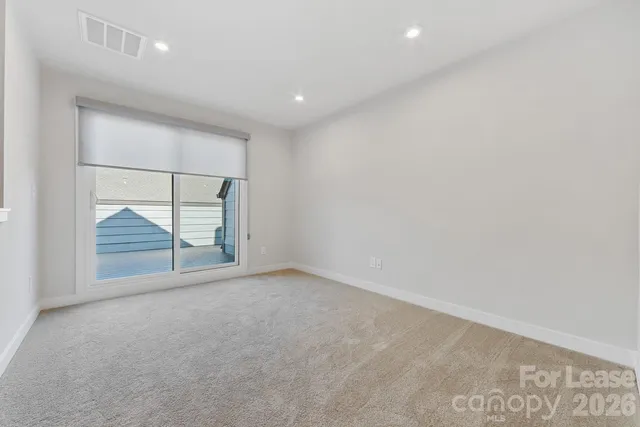 an empty room with large window and mirror