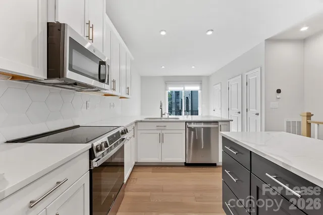 a kitchen with stainless steel appliances granite countertop a sink and a stove top oven