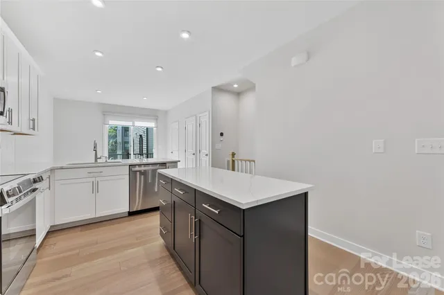 a kitchen with sink cabinets and wooden floor