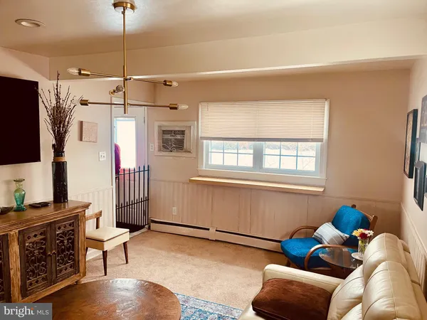 a living room with furniture a flat screen tv and a window