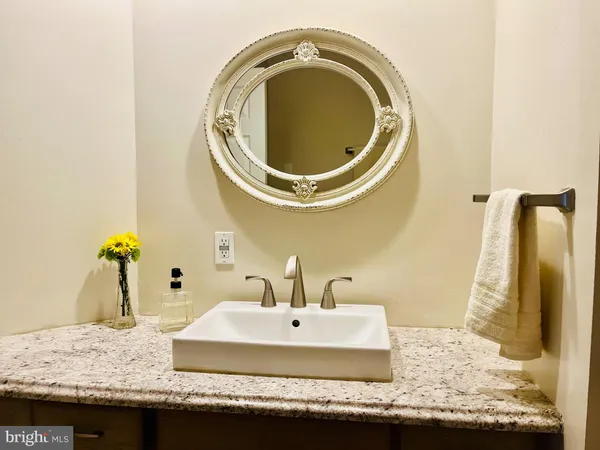 a bathroom with a granite countertop sink and a mirror