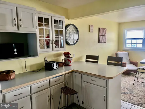a kitchen with cabinets a clock and a view of dining table