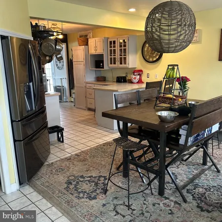 a kitchen with stainless steel appliances granite countertop a stove a refrigerator and a dining table with wooden floor