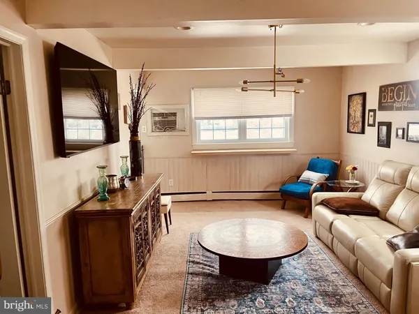 a living room with furniture a window and a flat screen tv