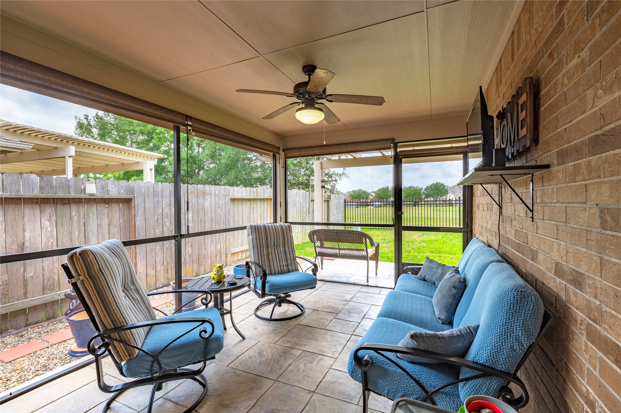 6822 Persea Ridge Lane Dickinson, TX 77539 - Photo 26 of 37 Step outside to this lovely enclosed patio with pull down shades, ceiling fan and beautiful flooring