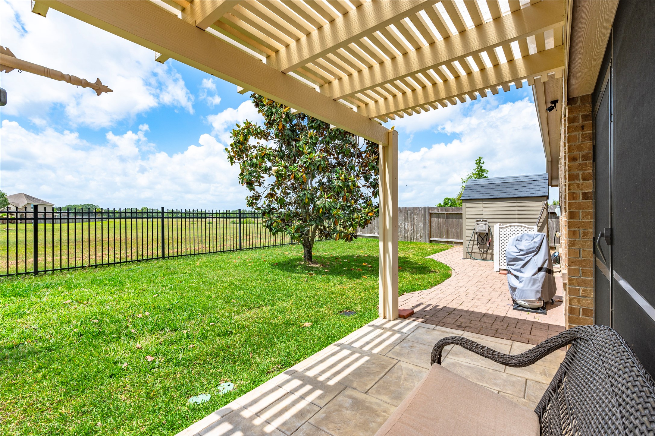 6822 Persea Ridge Lane Dickinson, TX 77539 - Photo 32 of 37 Step outside the patio enclosure to the walkway to the 7'x7' shed. Outside the patio has an added 12'x6' Pergola