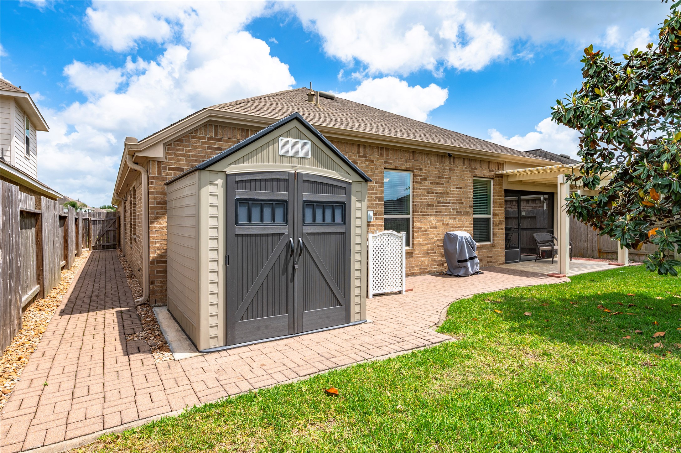 6822 Persea Ridge Lane Dickinson, TX 77539 - Photo 33 of 37 Paved walkway to the 7'x7' storage shed and walkway to the side gate