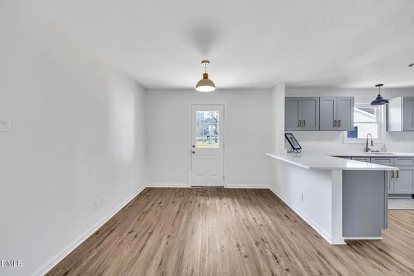 a view of a kitchen with wooden floor and a sink