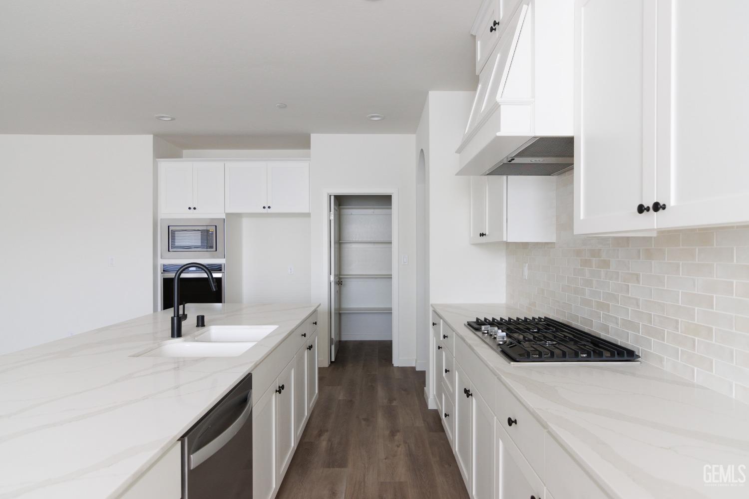 Undisclosed Address Bakersfield, CA 93311 - Photo 4 of 24 a kitchen with stainless steel appliances a sink stove top oven and cabinets