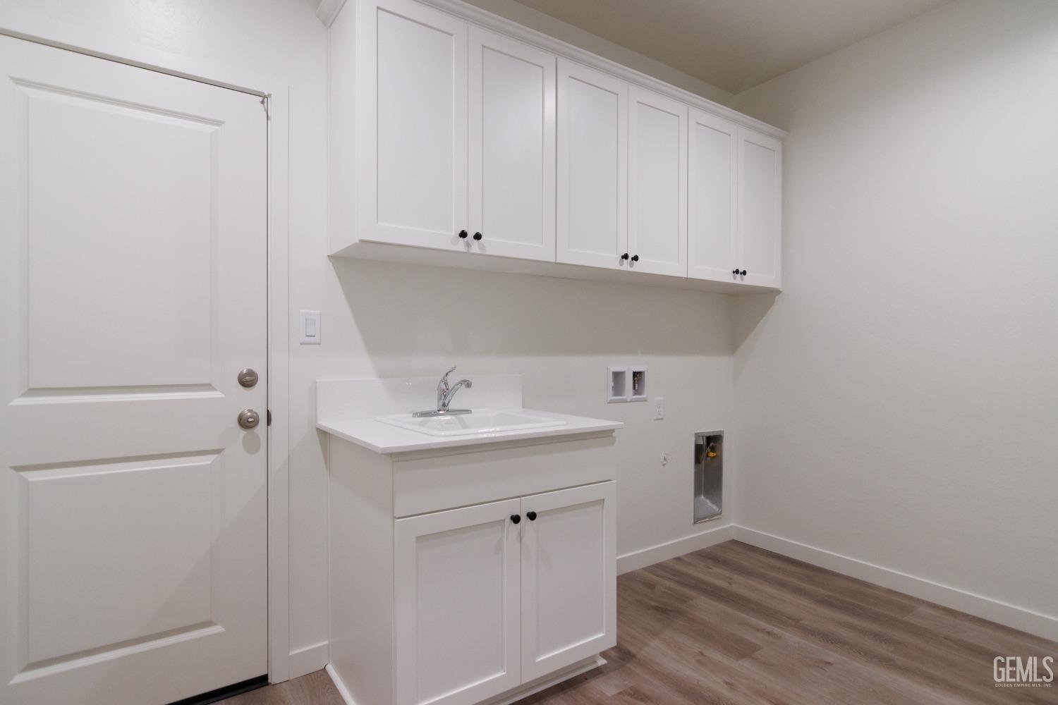 Undisclosed Address Bakersfield, CA 93311 - Photo 5 of 24 a view of a kitchen with white cabinets and a sink