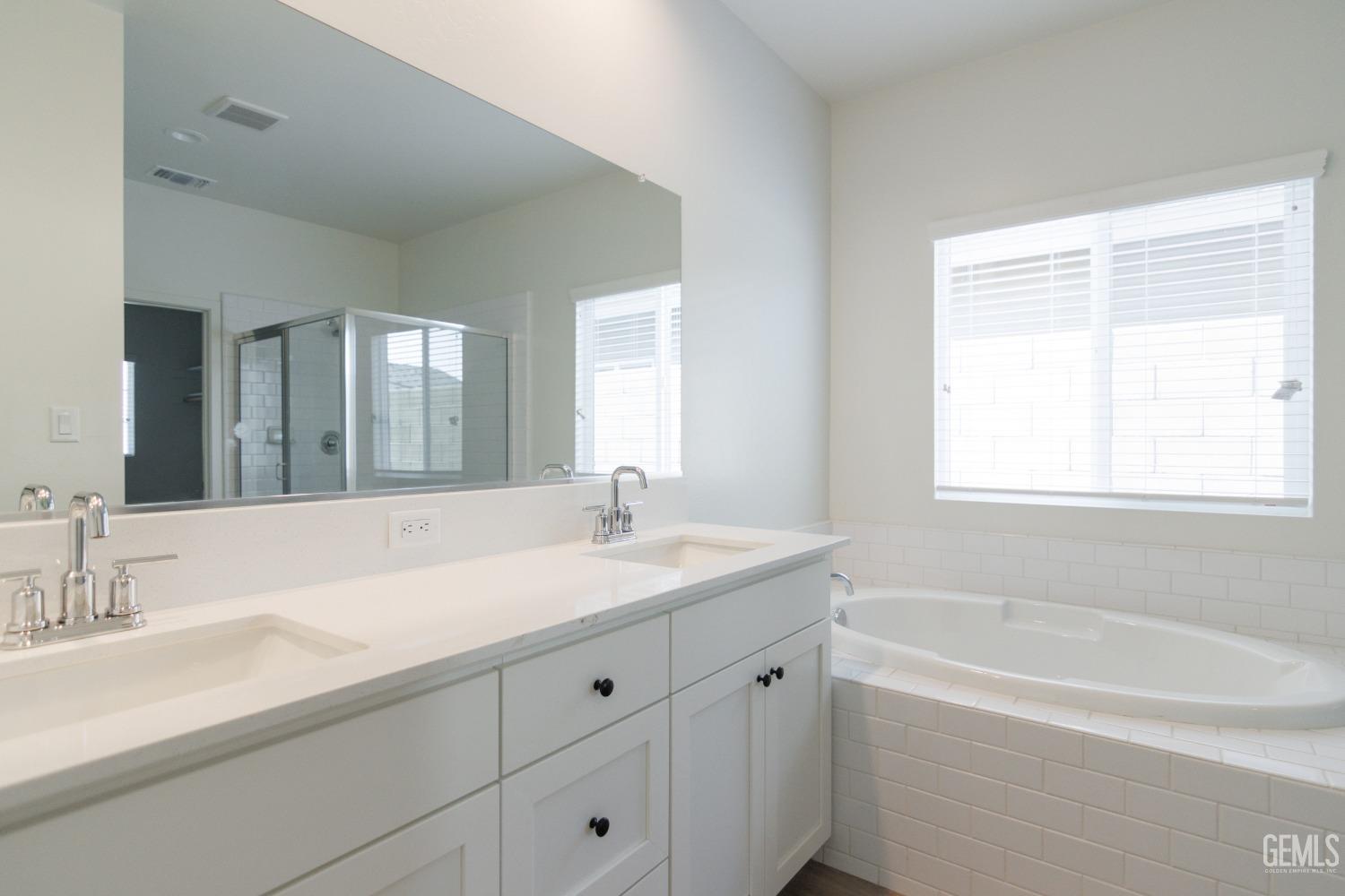 Undisclosed Address Bakersfield, CA 93311 - Photo 6 of 24 a bathroom with a sink double vanity granite tub and a mirror