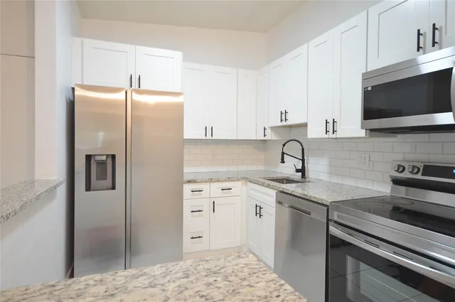 a kitchen with stainless steel appliances a sink cabinets and a counter top space