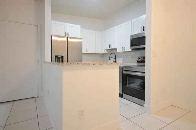 a kitchen with a refrigerator sink and cabinets