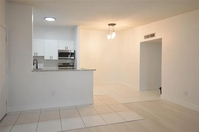 a kitchen with stainless steel appliances a refrigerator sink and microwave