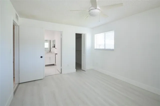 an empty room with fan and entrance