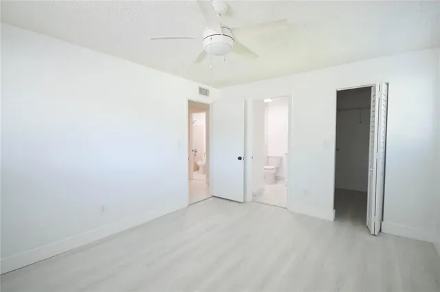 an empty room with fan and entrance