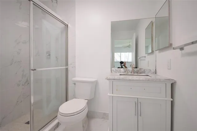 a bathroom with a granite countertop sink toilet and shower