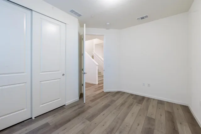 a kitchen with stainless steel appliances kitchen island granite countertop a stove a sink dishwasher and a refrigerator with wooden floor