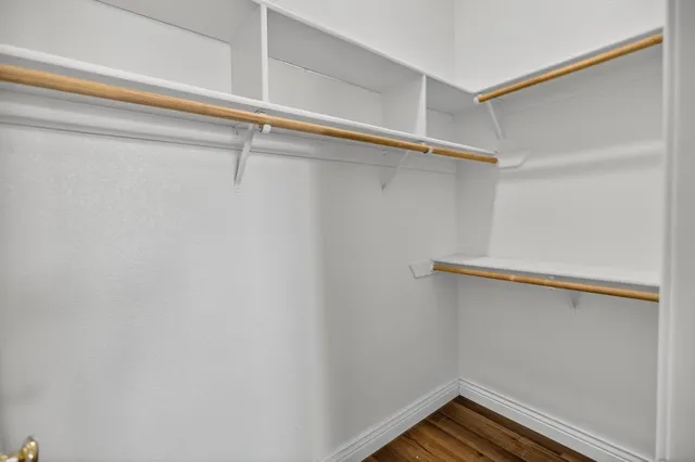 a view of walk in closet with clothes and shoes