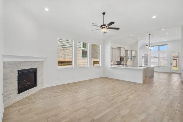 a view of an empty room with a fireplace and window
