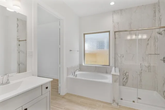 a bathroom with a bathtub shower sink vanity and toilet