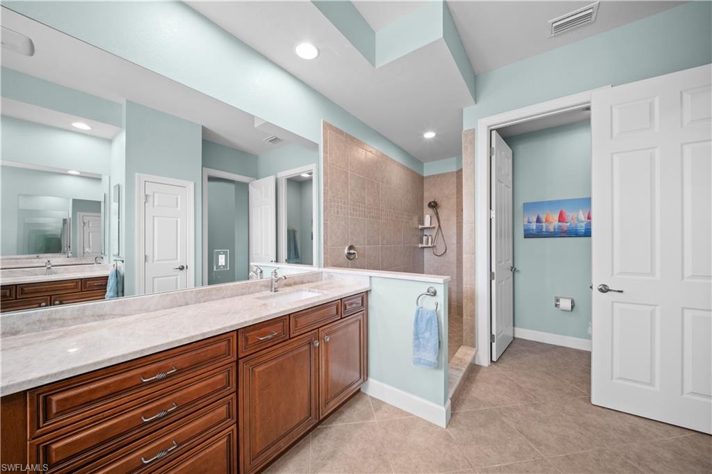 9220 Quartz Lane, Unit 202 Naples, FL 34120 - Photo 17 of 47 a spacious bathroom with a granite countertop sink mirror and shower