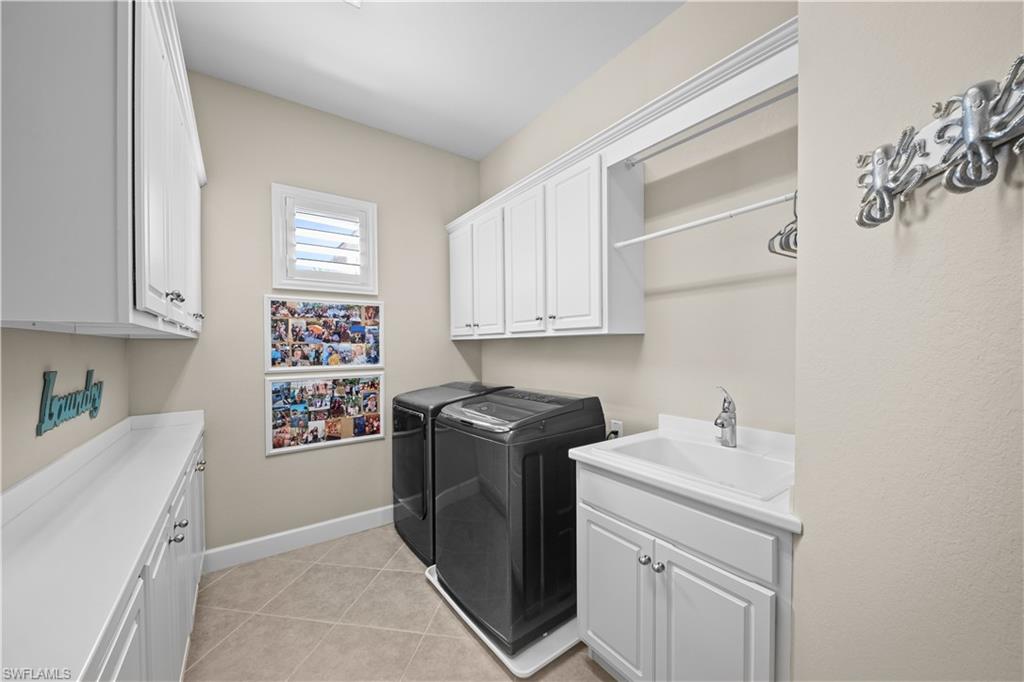 9220 Quartz Lane, Unit 202 Naples, FL 34120 - Photo 23 of 47 a view of cabinets a washer and dryer