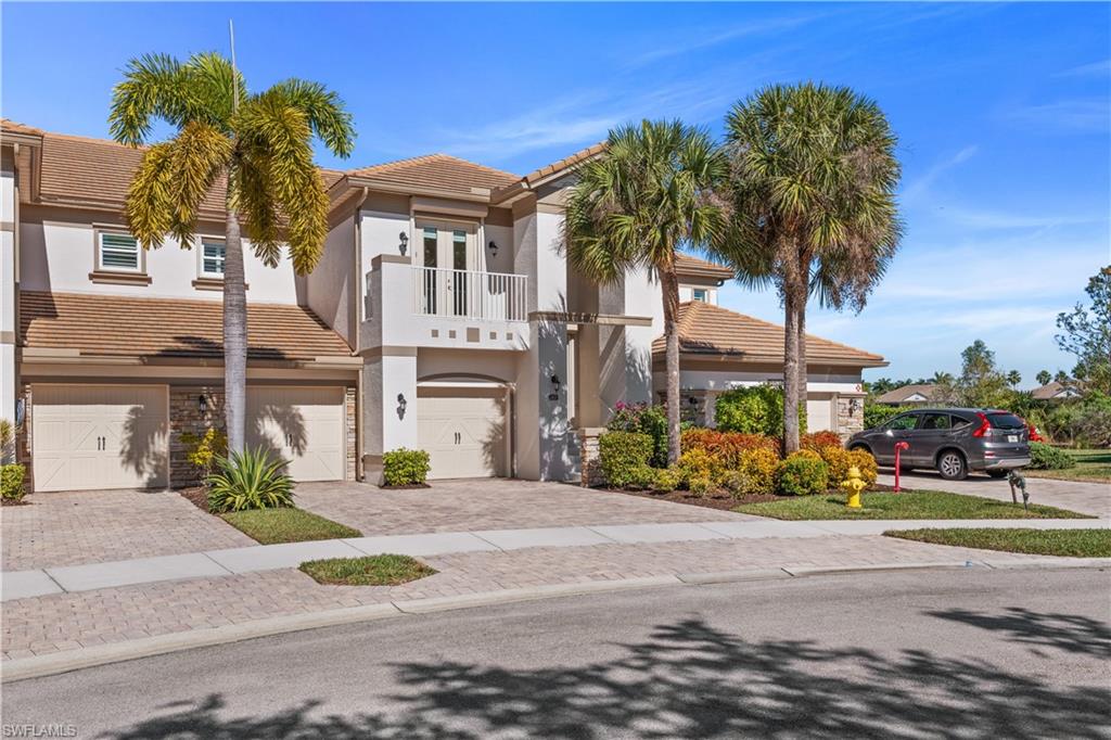 9220 Quartz Lane, Unit 202 Naples, FL 34120 - Photo 3 of 47 a front view of a house with a yard and garage
