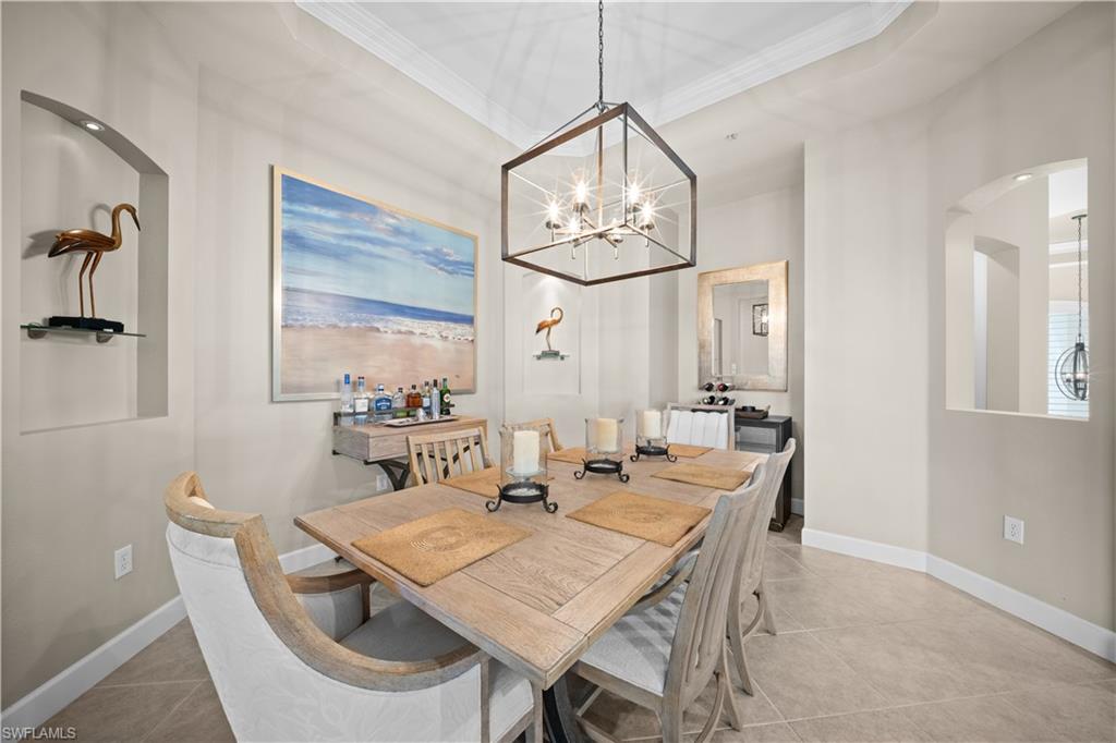 9220 Quartz Lane, Unit 202 Naples, FL 34120 - Photo 8 of 47 a view of a dining room with furniture a chandelier and wooden floor